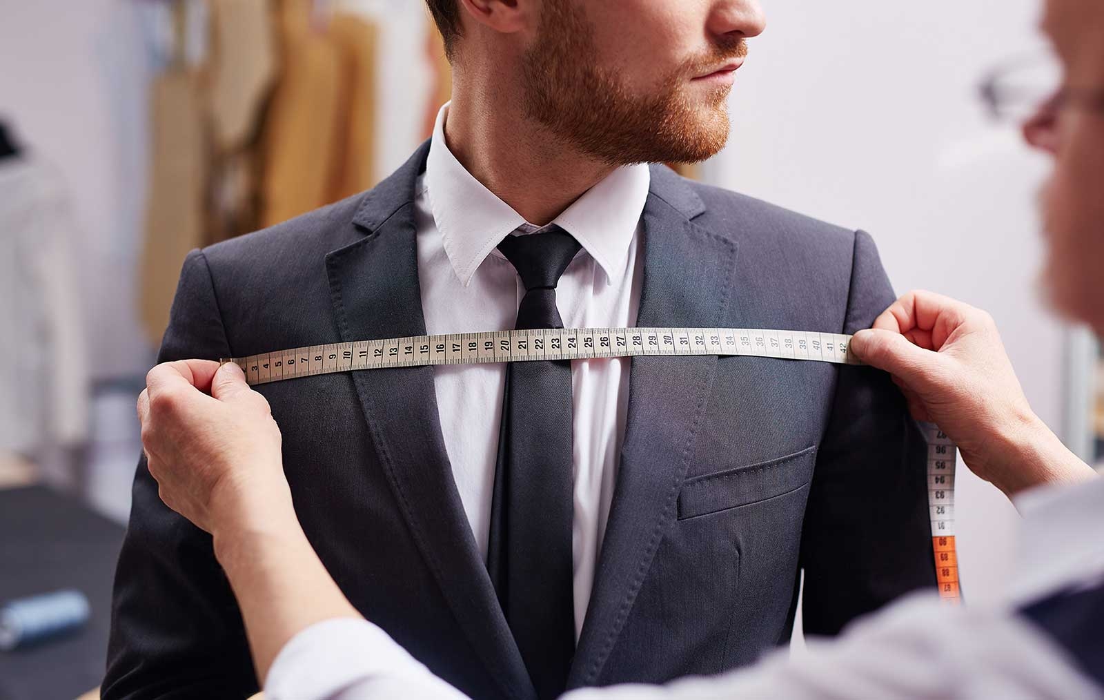 Sastre trabajando meticulosamente en un elegante traje a medida