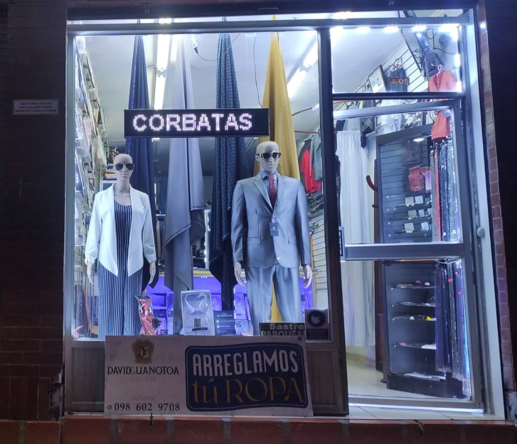 Vitrina de la sastrería en el C.C. Capelo Plaza con trajes, corbatas y el letrero de arreglos de ropa
